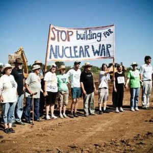 Demonstranter står med en banderoll "Stop building for Nuclear War"
